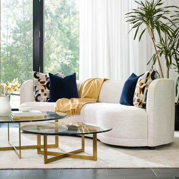 Century white upholstered sofa with tiered glass console table